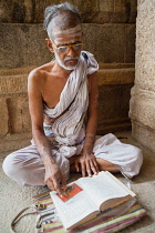 India, Tamil Nadu, Tiruchirappalli, Trichy, A saddhu reading sacred text at the Sri Ranganathaswamy Temple in Srirangam near Tiruchirappalli.