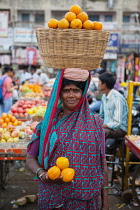 India, Karnataka, Mysore, Woman selling oranges at Devaraja Market in Mysore.