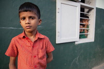 India, Kerala, Ponnani, Portrait of a boy standing outside his family home in Ponnani.