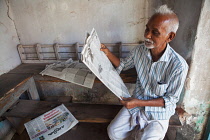 India, Kerala, Fort Cochi, Man reading a newspaper .