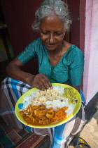 India, Kerala, Anjengo, Woman eating a thali.