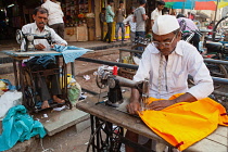 India, Karnataka, Bijapur, Tailors using sewing machines in the market district of Bijapur.