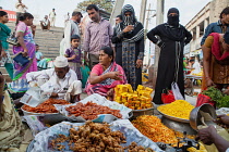 India, Karnataka, Bijapur, Sweet food and snack vendor in Bijapur market.