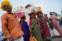 India, Karnataka, Bijapur, A group of men and women wait for a public bus outside the main market of Bijapur.