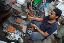 India, Maharashtra, Dhule, Preparing lamb kebabs in the market at Dhule.