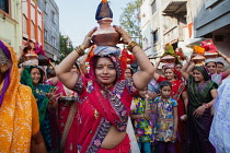 India, Maharashtra, Dhule, A procession of women celebrate a local festival in the streets of Dhule.