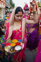 India, Maharashtra, Dhule, A woman with a tray of offerings dances to celebrate a local festival in the streets of Dhule.