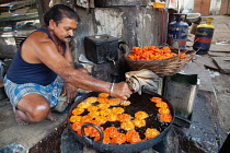 India, Madhya Pradesh, Maheshwar, Man cooking jalebis.