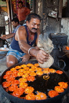 India, Madhya Pradesh, Maheshwar, Man cooking jalebis.
