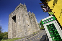 Ireland, County Clare, Bunratty Castle with traditional Irish telephone box nearby.