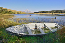 Ireland,County Donegal, Clady River with Mount Errigal in the distance and a rowing boat in the foreground.