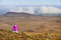 Ireland, County Fermanagh, Cuilcagh Mountain Park, Hiker enjoying the view from the summit of Cuilcagh Mountain.