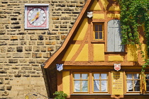 Germany, Bavaria, Rothenburg ob der Tauber, Facade of a colourful half timbered house with a clock on the wall.