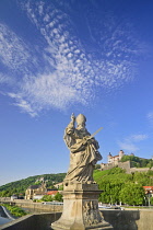 Germany, Bavaria, Wurzburg, Festung Marienberg fortress above the River Main with a statue of St Kilian on Alte Mainbrucke.