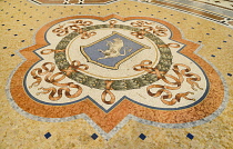 Italy, Lombardy, Milan. Galleria Vittorio Emanuele, Famous bull mosaic on the floor where tradition says that if a person spins around three times with a heel on the testicles of the bull on the Turin...