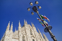 Italy, Lombardy, Milan. Milan Duomo or Cathedral, A section of the facade with a lamp post adorned by Italian flags.
