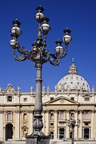 Italy, Vatican City, St Peters Square with the facade and dome of St Peters Basilica beyond a streetlamp.