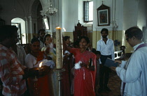 India, Goa, Margao, Lighting candle during christening ceremony.