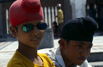 India, Delhi, Two sikh boys one in mirror sunglasses. Head and shoulders portrait.