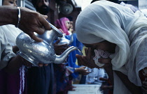 India, Delhi, Pouring water for Sikh pilgrims to wash at temple.