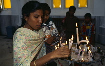 India, Karnataka, Mysore, Indian women lighting candles.
