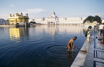 India, Punjab, Amritsar, Man bathing in sacred pool of the Golden Temple complex.