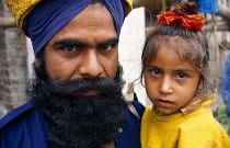India, Delhi , Head and shoulders portrait of Sikh father and daughter.