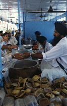 India, Delhi , Volunteers giving out food in Sikh temple kitchen.