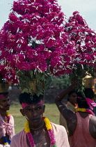 India, Kerala, Man in Festival Parade wearing large floral head dress.