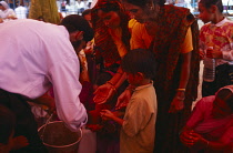 India, Punjab, Amritsar, Volunteers give out karah parshad a sacred sweet made from flour semolina sugar water and butter at temple during birthday celebrations for Guru Granth Sahib.