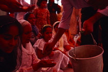 India, Punjab, Amritsar, Volunteers give out Karah Parshad a sacred sweet made from flour semolina sugar water and butter during birthday celebrations for Guru Granth Sahib.