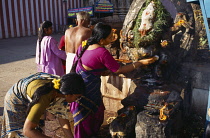 India, Tamil Nadu, Madurai, Making offerings ar shrine dedicated to Ganesh.