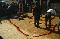 Nepal, Kathmandu, Nepalese army soldiers making animal sacrifice and adding to shrine of offerings.