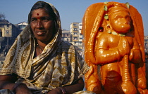 India, Maharashtra, Nasik, Woman devotee beside shrine dedicated to Hanuman the monkey god.