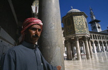 Syria, South, Damascus, Pilgrim at the Umayyad Mosque with the Dome of the Treasury and the Minaret of the Bride in the background.