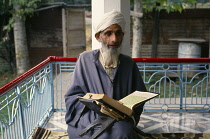 India, Kashmir, Religion, Muslim man reading from the Koran.