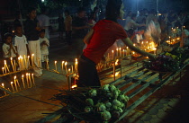 Thailand, South, Hua Hin, People lighting candles and incense sticks with lotus flower offerings at a temple during Magha Puja.