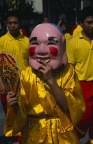 Thailand, North, Chiang Mai, Chinese New Year. Figure in costume and mask holding fan during Dragon Dance.