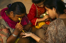 India, Religion, General, Henna being applied to a womans palm by another woman