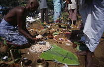 Sri lanka, Haputale, Funeral ritual with son of the deceased with head shaved as sign of bereavement placing offerings on ground marked with coloured tika powder.