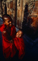 Myanmar, Mandelay, Two laughing  young novice monks in the Royal Pagoda.
