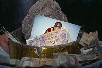 India, Ladakh, Religion, Temple offering bowl contining picture of the Dalai Lama and money.