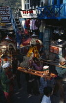 India, Himachal Pradesh, Kullu, Men carrying decorated figures of temple gods through street during Dussehra Festival.