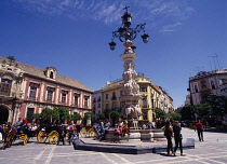 Spain, Andalucia, Seville, Santa Cruz District  Plaza Virgen de los Reyes  Palacio Arzobispal on the left  fountain  horse carriages  people.