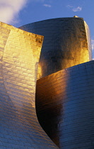 Spain, Basque Province, Bilbao, Exterior of the Guggenheim Museum in warm light, designed by Frank Gehry.