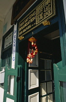 Singapore, Chinatown, Chinese New Year decoration hanging in door way .