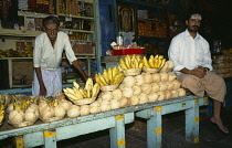 India, Hindu temple offerings with men standing by.