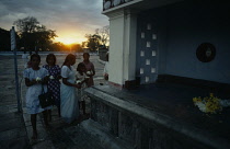 Sri Lanka, Anuradhapura , Wesak Festival, Women with flower offerings at sunset.