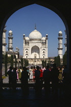 India, Maharashtra, Aurangabad, Bibi-ka-Maqbara the poor man s Taj Mahal. Built 1679 as a mausoleum for Aurangzeb s wife Rabia-ud-Daurani, Exterior and silhouetted visitors framed in arch.