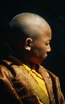 China, Tibet, Samye Monastery, Near Tsetsang, Young novice monk head and shoulders portrait profile right.